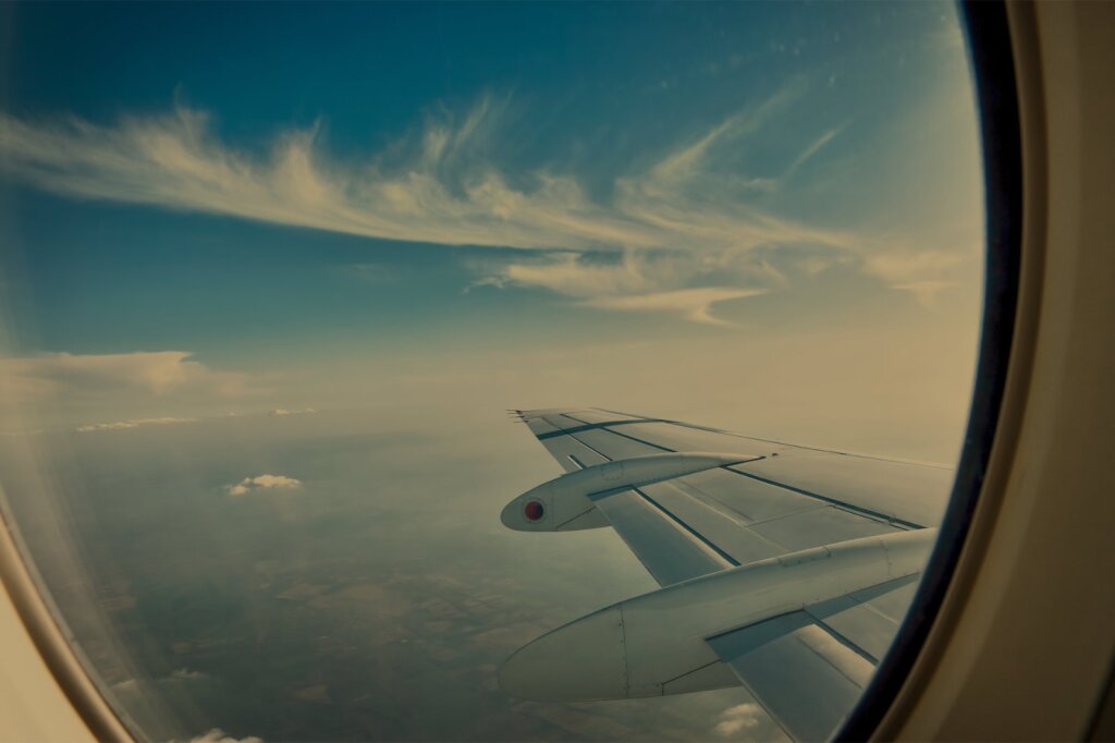 Window in a airplane with view accros the wing.